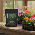 Organitek Flower Republic BudTone:PK powder available in a 5 lbs black pouch situated on a gardening table in a greenhouse.