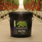 A black plastic 10lb bucket of Flower Republic BudTone:PK powdered fertilizer, featuring a green bear logo and purple label accents.