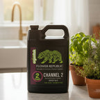 Flower Republic Channel 2 1 gallon on a counter adjacent to fresh herbs